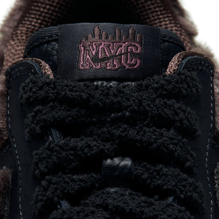 Close-up of Nike Air Force 1 tongue featuring brown fuzzy material, black textured leather, and NYC skyline embroidery.