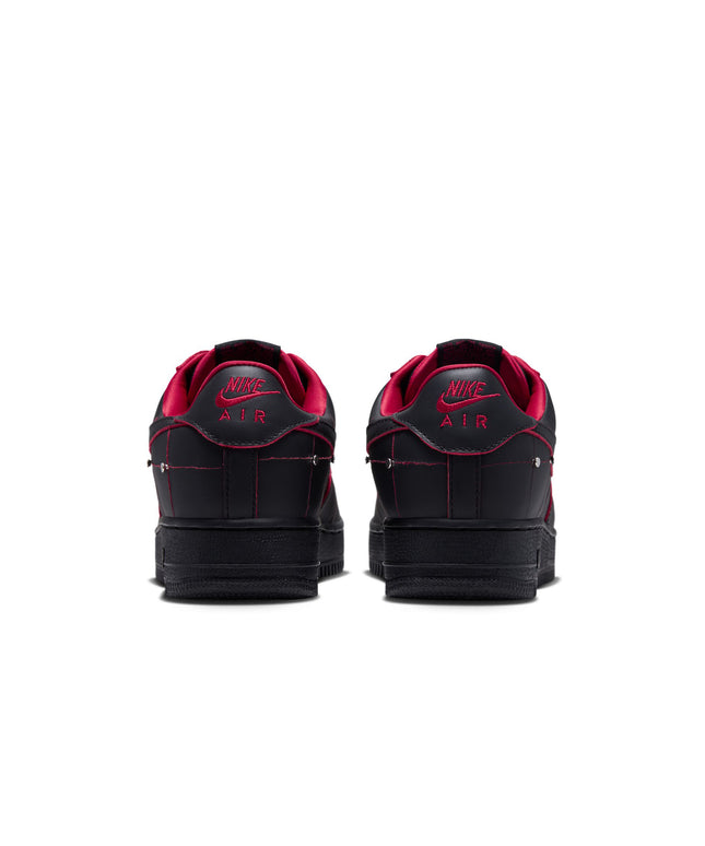 Back view of black leather Nike Air Force 1 sneakers with gym red lining, contrast stitching, and metallic details.