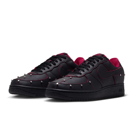 Nike Air Force 1 low-top sneakers in black leather featuring silver stud detailing, red trim, and gym red inner lining.