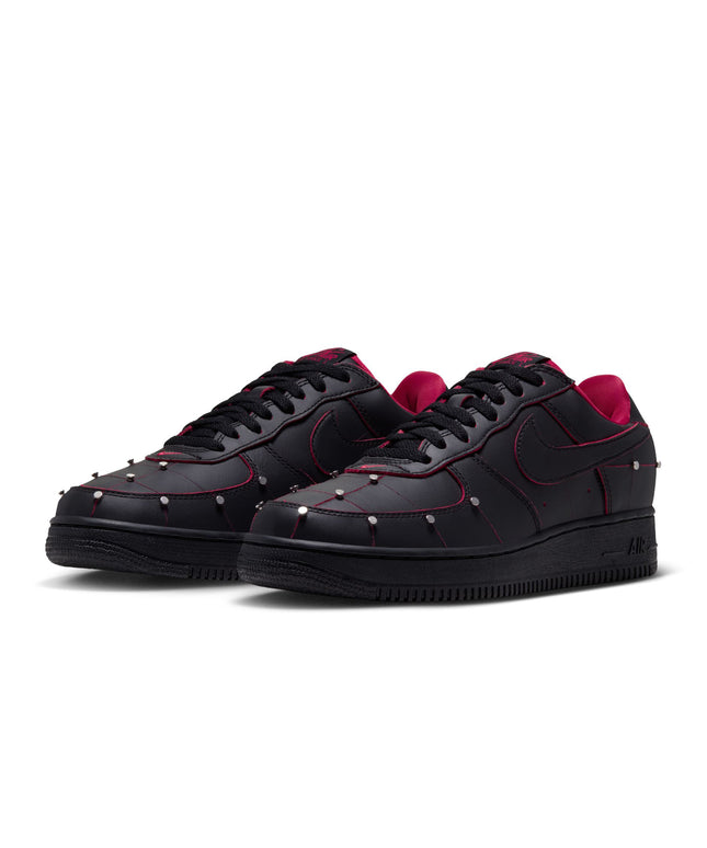 Nike Air Force 1 low-top sneakers in black leather featuring silver stud detailing, red trim, and gym red inner lining.