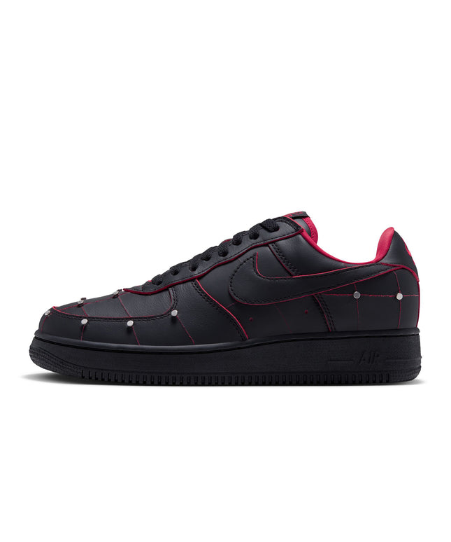 Nike Air Force 1 low-top sneaker in black leather with gym red piping, metallic silver studs, and a black rubber sole.