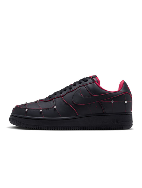 Nike Air Force 1 low-top sneaker in black leather with gym red piping, metallic silver studs, and a black rubber sole.