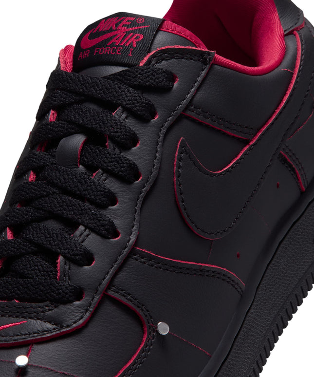Nike Air Force 1 low-top sneaker in black leather with gym red piping, metallic silver studs, and red interior lining.