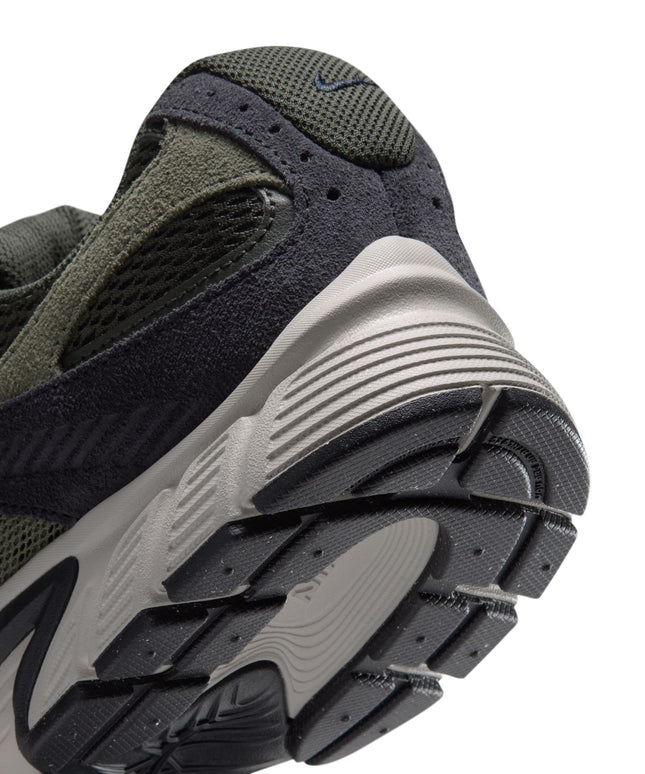 Close-up view of the heel of a Nike V5 RNR sneaker featuring olive green mesh, black suede overlays, and beige sole.