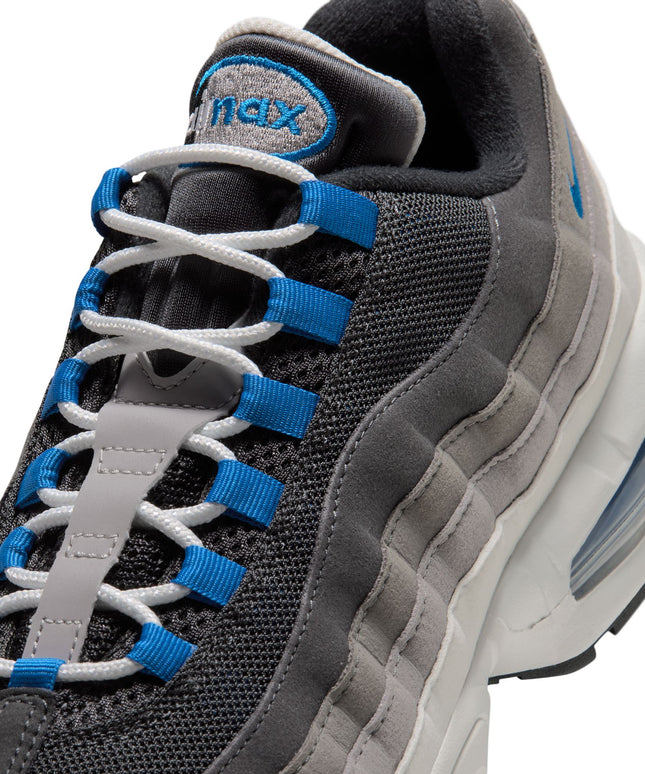 Close-up of Nike Air Max 95 sneaker in anthracite and blue spark with grey suede overlays and white lace details.
