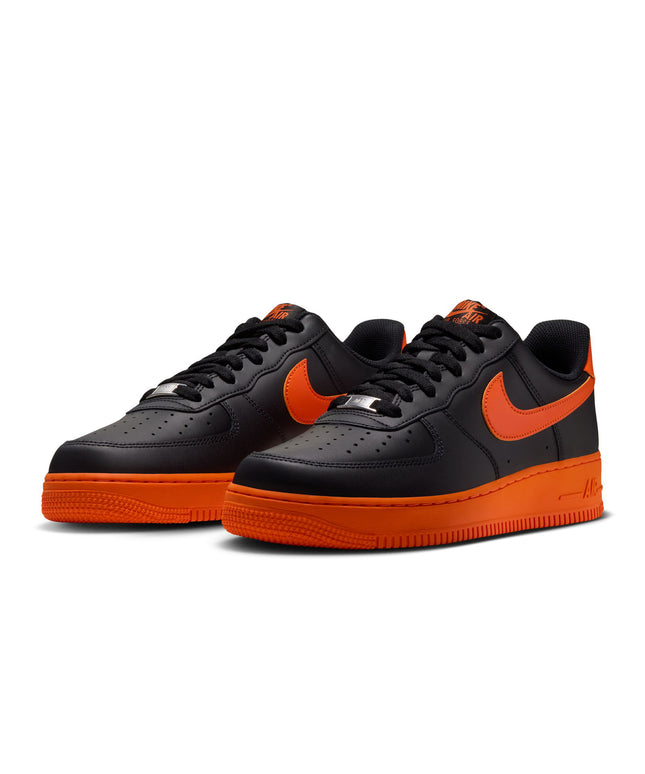 Nike Air Force 1 '07 low-top sneaker featuring a black leather upper, vibrant orange Swoosh, and matching orange sole.
