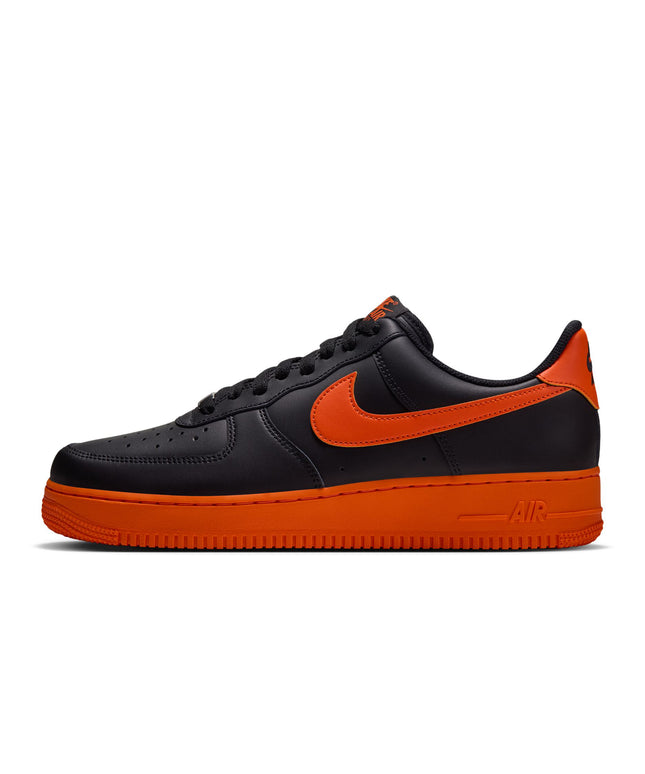 A Nike Air Force 1 Low sneaker in black and bright orange, shown from a side profile view against a plain white background.