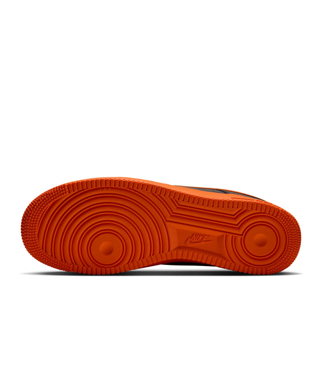 Vibrant orange rubber outsole of a Nike Air Force 1 '07 sneaker featuring a classic circular traction tread pattern.