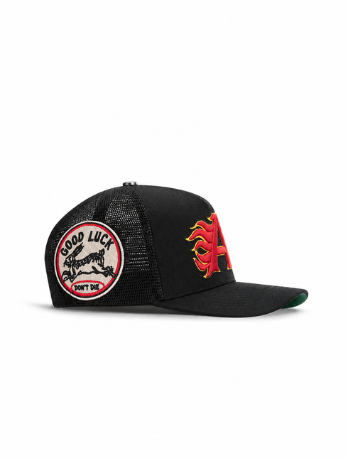 All Human King v2 trucker hat in black featuring a red and yellow flame-style letter A and a Good Luck rabbit patch.