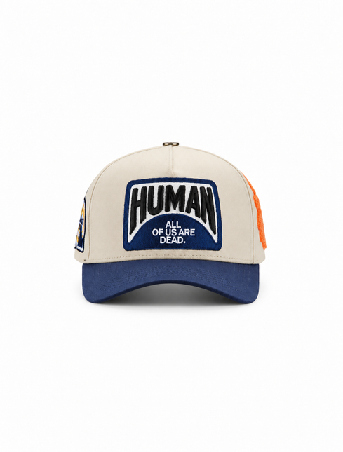 All Human THE CURE baseball cap in cream and navy with a prominent embroidered front patch and text logo.
