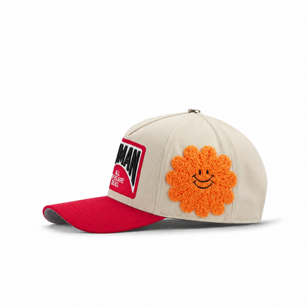 All Human EBT cap in cream canvas with a red bill, featuring a red text patch and a textured orange fuzzy smiley flower.