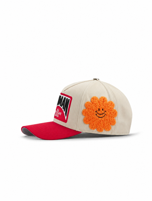 All Human EBT cap in cream canvas with a red bill, featuring a red text patch and a textured orange fuzzy smiley flower.
