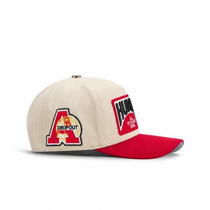 Cream canvas baseball cap by All Human with a red brim, embroidered red A Dropout logo, and black Human text patch.