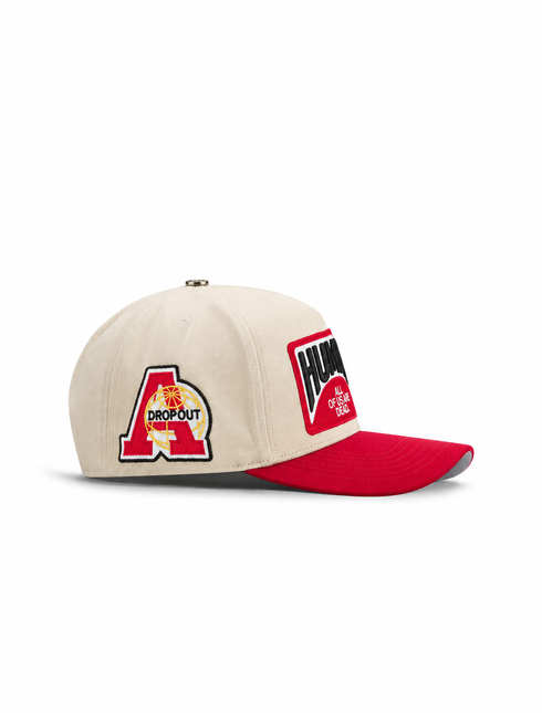 Cream canvas baseball cap by All Human with a red brim, embroidered red A Dropout logo, and black Human text patch.