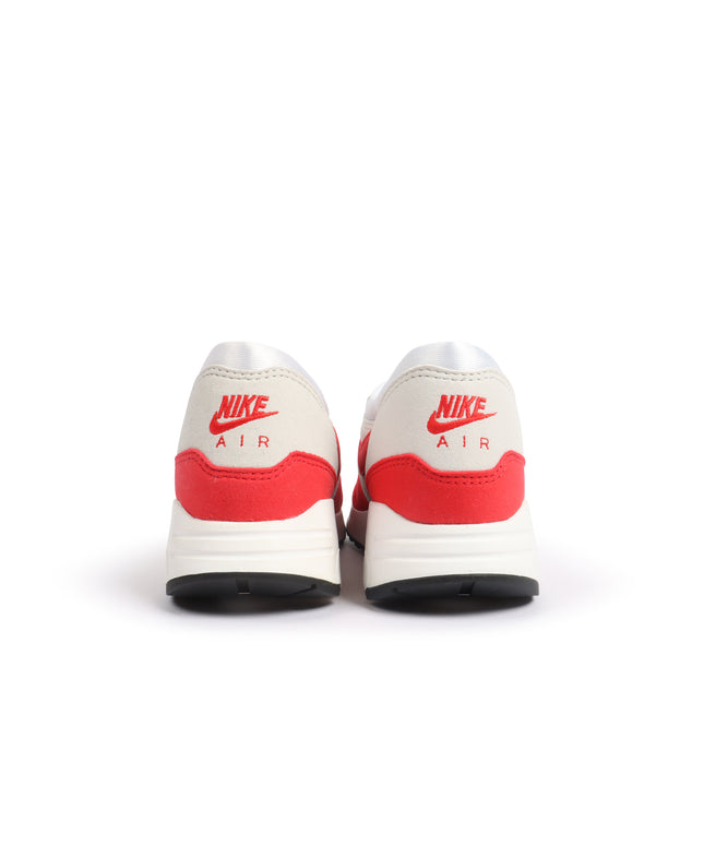 Back view of white and red Nike Air Max 1 '86 OG sneakers featuring a smooth leather upper and vibrant suede heel panel.