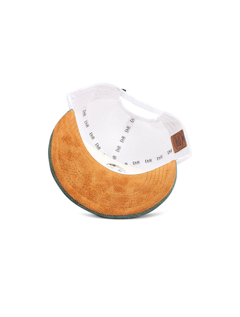 Upside-down view of a white baseball cap showing the tan corduroy underbrim and a small brown leather patch.
