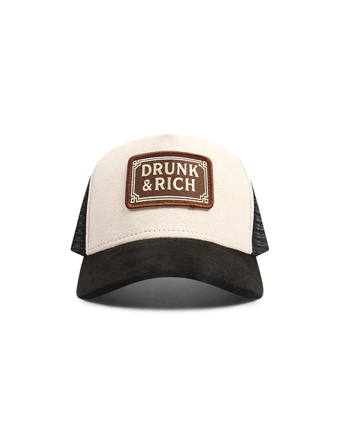 Drunk & Rich trucker hat featuring a cream suede front panel, black suede curved brim, and black mesh back panels.