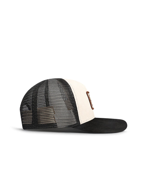 A black and off-white trucker cap with a black mesh back, black brim, and a small brown leather patch on the side.