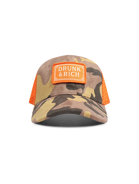A camouflage trucker hat with orange mesh back panels and an orange patch on the front that reads 'DRUNK & RICH'.