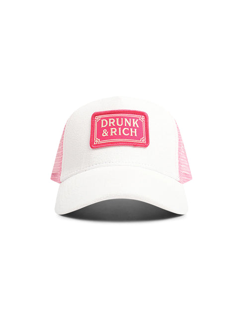 White suede trucker hat featuring pink mesh back panels and a rectangular front patch displaying DRUNK & RICH text.