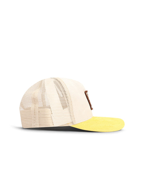 Drunk & Rich trucker hat featuring a cream canvas front, breathable mesh back, bright yellow suede visor, and logo.