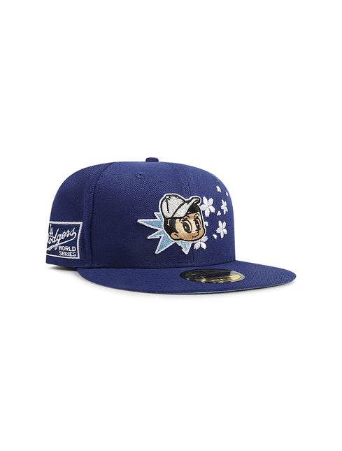 Navy blue fitted baseball cap with an embroidered cartoon character surrounded by stars and a Dodgers patch on the side.