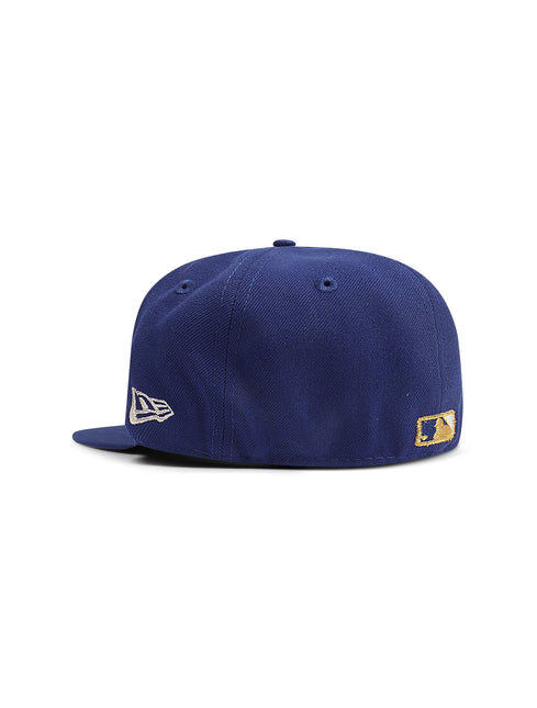 Back view of a navy blue fitted baseball cap with a New Era logo and a small gold MLB patch.