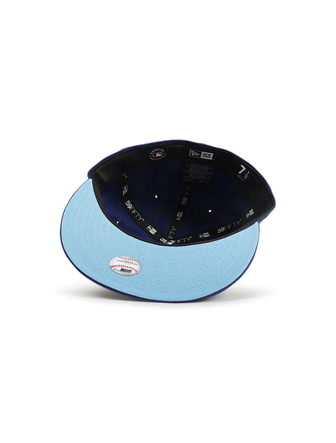 Upside-down view of a navy blue fitted baseball cap showing the light blue underbrim and dark interior lining.