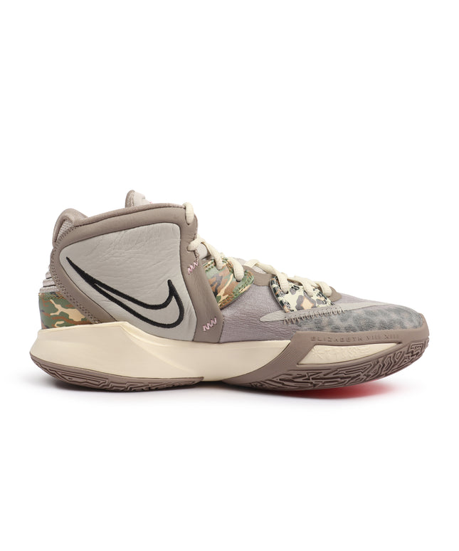 Nike Kyrie Infinity sneaker in tan with camo and leopard print panels, a black swoosh, and textured rubber sole.
