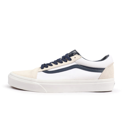 Vans Old Skool sneaker featuring a white canvas upper, navy side stripe, navy laces, and beige suede toe and heel caps.