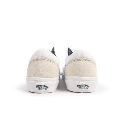 Back view of white and navy Vans Old Skool sneakers featuring beige suede heel counters and white rubber outsoles.