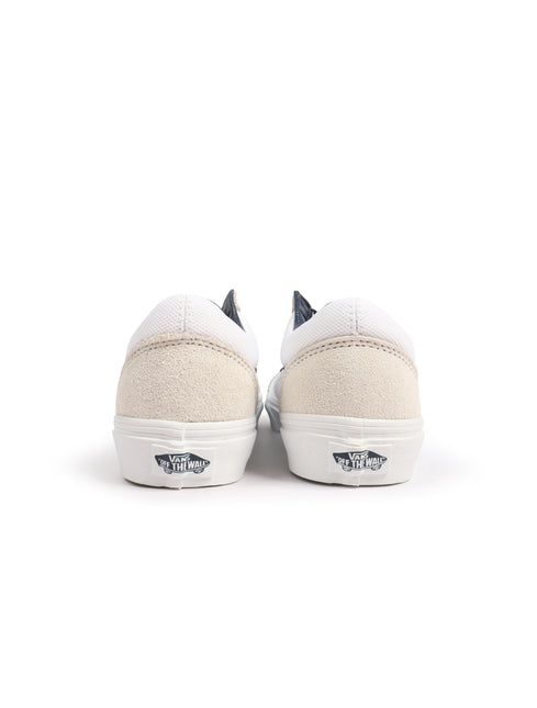 Back view of white and navy Vans Old Skool sneakers featuring beige suede heel counters and white rubber outsoles.