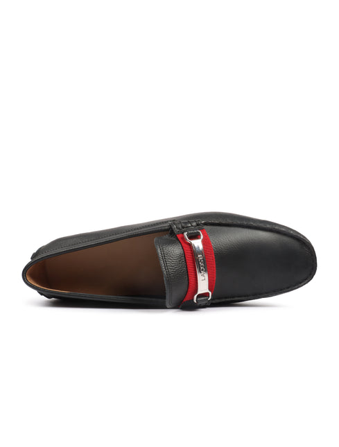 Lacoste black leather loafers featuring a textured finish with a central red fabric strap and silver metallic buckle.