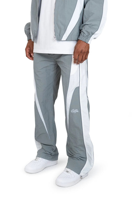 EPTM Legacy pants in grey and white nylon with a panelled design, worn with white sneakers against a plain background.
