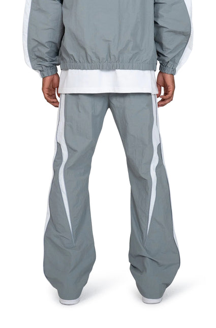 EPTM Legacy pants in grey featuring a lightweight windbreaker finish, wide-leg fit, and bold white curved side stripes.