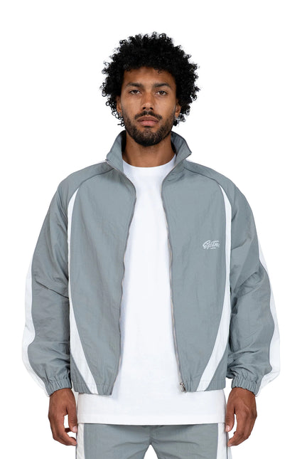 EPTM Legacy zip-up windbreaker jacket in grey with white side panels and matching grey sweatpants on a model.