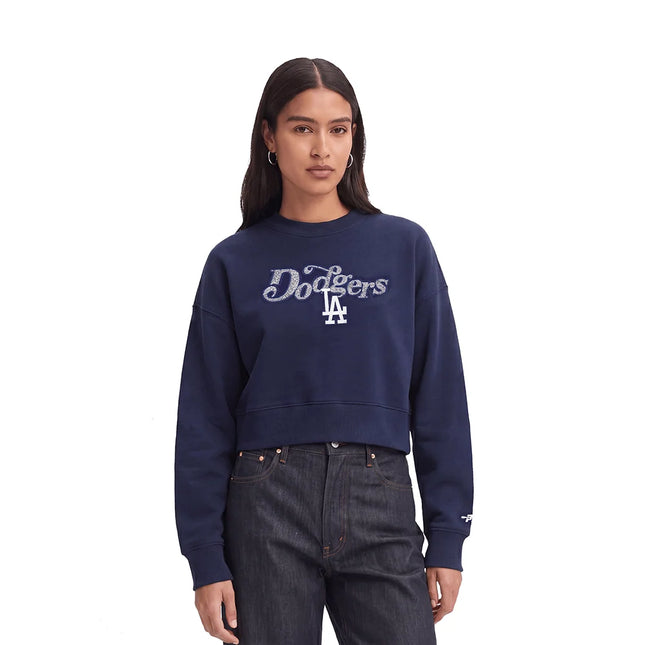 Person wearing a navy blue Los Angeles Dodgers sweatshirt on a white background