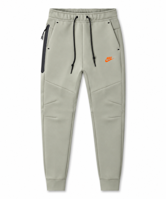 Nike Men's Tech Fleece joggers in light army green with black drawstrings, side zip pocket, and orange logo detail.