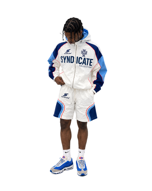 Syndicate nylon tracksuit set in white with blue and red accents, featuring a zip-up hoodie and matching logo shorts.