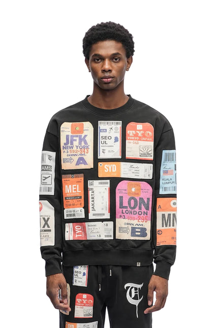 Black cotton crewneck sweater by Trnchs featuring a collage of colorful vintage-style international travel tags.