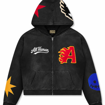 All Human black wash zip-up hoodie featuring a red flame letter A, yellow star, blue skull, and red star patches.