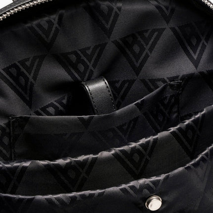 Interior of a black Valabasas La Borsa backpack featuring a patterned nylon lining and a secure leather strap tab.