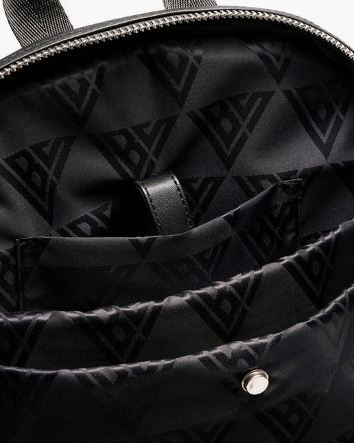 Interior of a black Valabasas La Borsa backpack featuring a patterned nylon lining and a secure leather strap tab.