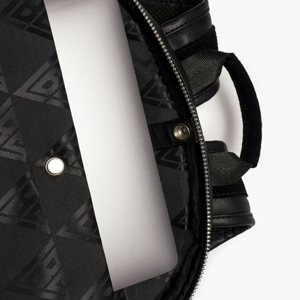 Interior view of a black Valabasas La Borsa backpack featuring a metallic silver laptop tucked inside the main pocket.