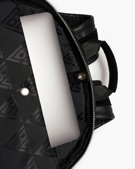 Interior view of a black Valabasas La Borsa backpack featuring a metallic silver laptop tucked inside the main pocket.