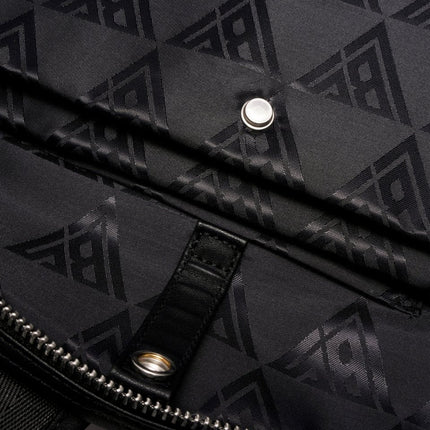 Close-up of a black Valabasas La Borsa backpack featuring a repeating triangular logo pattern on durable fabric.
